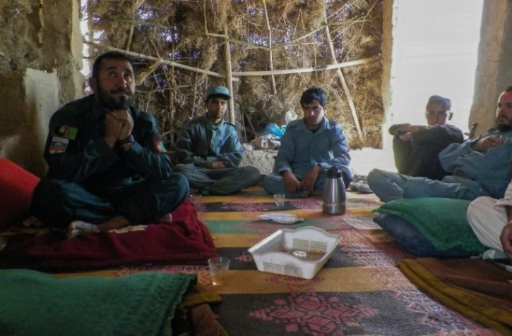 Le chef de la police Seddigullah, à gauche, entouré de ses subordonnés lors d'une interview à l'AFP le 28 avril 2016