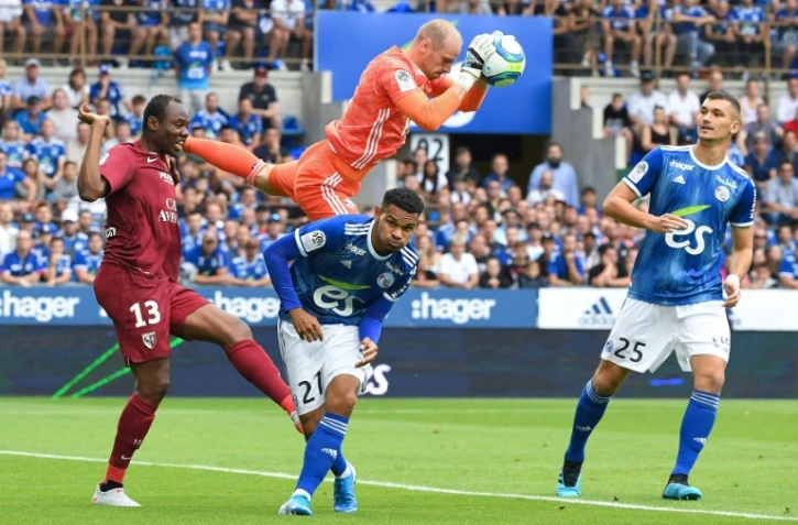 Le gardien de but strasbourgeois Mats Sels s'empare du ballon devant son coéquipier Kenny Lala (c) et le Messin Stoppila Sunzu (g), le 11 août 2019 à Strasbourg