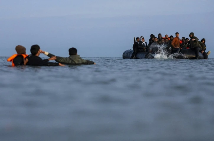 Des migrants essaient de monter à bord d'un "bateau-taxi" pour traverser la Manche le 19 septembre 2025 au large de la plage de Gravelines, dans le nord de la France
