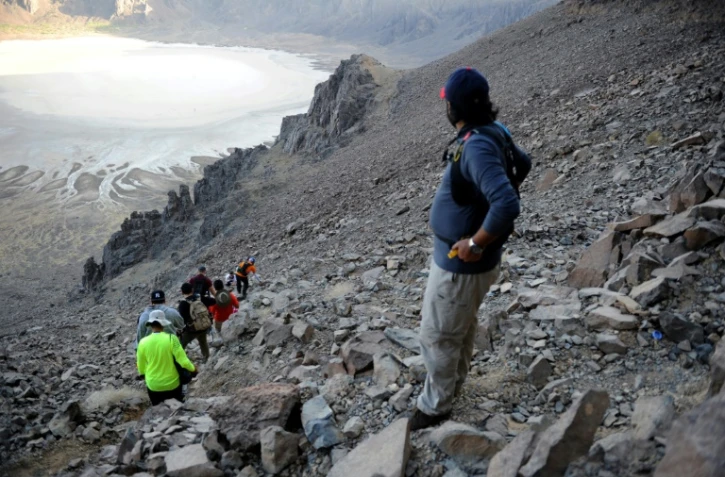 Des randonneurs et leur guide s'approchent du cratère volcanique d'Al Wahbah, à quelque 360 km au nord-est de Jeddah, en Arabie saoudite, le 17 novembre 2017