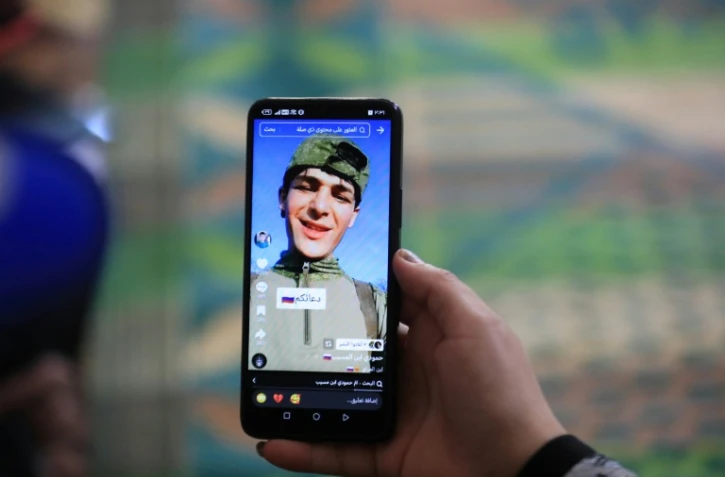 Une photo du jeune Irakien Mohammed Imad, publiée sur les réseaux sociaux après son départ pour se battre dans l'armée russe en Ukraine, visible sur un téléphone portable au domicile familial à Musayab, au sud de Bagdad, le 10 septembre 2025