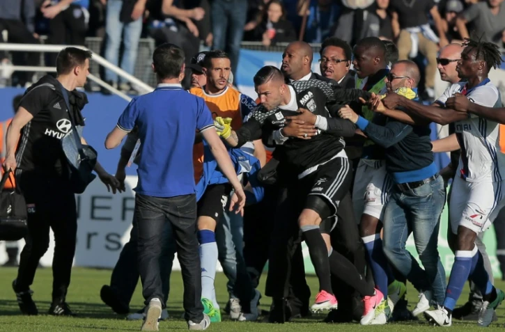 Le portier Anthony lyonnais Lopes est retenu par des membres de la sécurité lors d'échauffourées à Bastia, le 16 avril 2017
