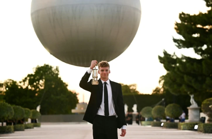 L'extinction de la vasque olympique par le nageur français Léon Marchand, quadruple médaillé d'or, au jardin des Tuileries à Paris le 11 août 2024