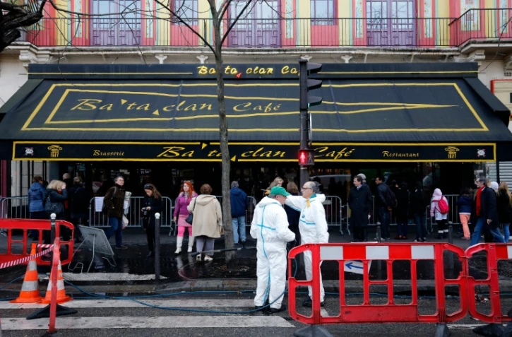 Des agents municipaux nettoient la façade et le trottoir devant le Bataclan à Paris, le 22 décembre 2015