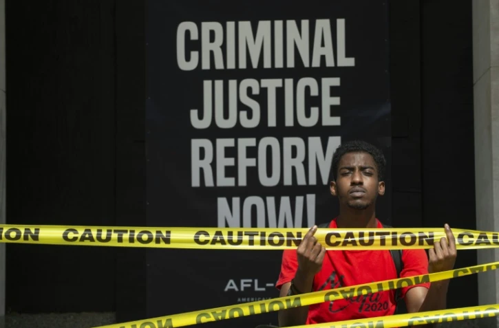 Moah Pollas, pose devant une pancarte peinte près du parc Lafayette, à proximité de la Maison Blanche, à Washington, le 5 juin 2020