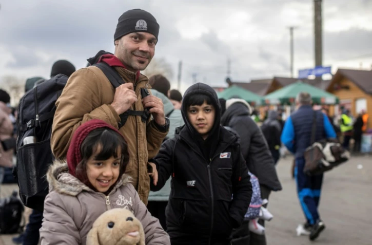 L'Afghan Ajmal Rahmani et ses enfants arrivés en Pologne à pieds à Medyka, avec d'autres réfugiés de pays différents, après avoir fui les combats en Ukraine, le 27 février 2022