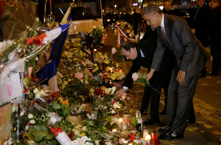 Les présidents français François Hollande et américain Barack Obama, se recueillent une rose blanche à la main, devant le Bataclan le 30 novembre 2015 à Paris