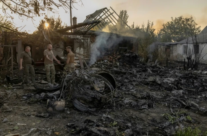 Des enquêteurs ukrainiens examinent l'épave d'un drone de combat russe à Kostyantynivka, dans la région orientale de Donetsk, le 5 octobre 2024