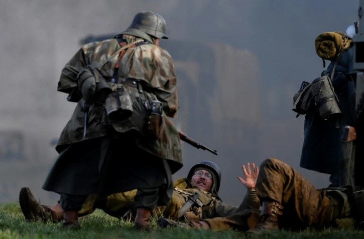Un acteur en uniforme allemand de la Seconde Guerre mondiale lors d'une scène de capture de soldats américains durant une reconstitution de la bataille des Ardennes, à Hardigny (Belgique) le 15 décembre 2019