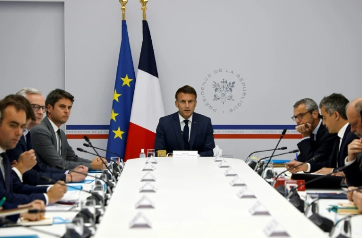 Le président Emmanuel Macron (au centre), flanqué du Premier ministre Gabriel Attal (3e à gauche), du ministre de l'Économie Le Maire (2e à gauche), du ministre français des Armées Sébastien Lecornu (à gauche) et du ministre de l'Intérieur et outre-mer Gérald Darmanin (2e à droite), au palais présidentiel de l'Elysée à Paris, le 16 mai 2024