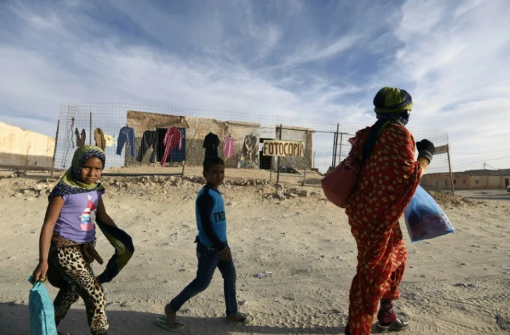 Une mère sahraouies et ses deux enfants vont faire des courses dans le camp de réfugiés de Smara près de près de Tindouf en Algérie, le 25 février 2016 