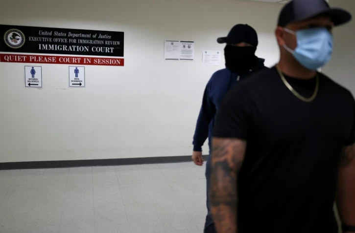 Des officiers en civil de la police fédérale de l'immigration (ICE) attendent dans un couloir d'un tribunal fédéral de l'immigration à New York le 6 juin 2025.
