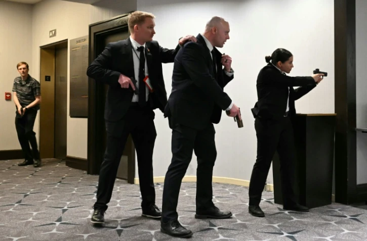 Des agents sont armes au poing après que des détonations ont été entendues au dîner des correspondants de la Maison Blanche, à l'hôtel Washington Hilton, le 25 avril 2026 à Washington