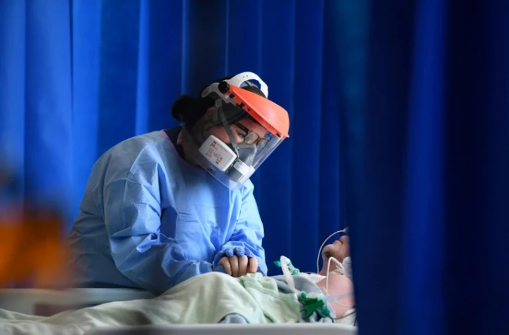 Une soignante réconforte un patient atteint par le Covid-19 dans un hôpital de Cambridge, le 5 mai 2020 au Royaume-Uni