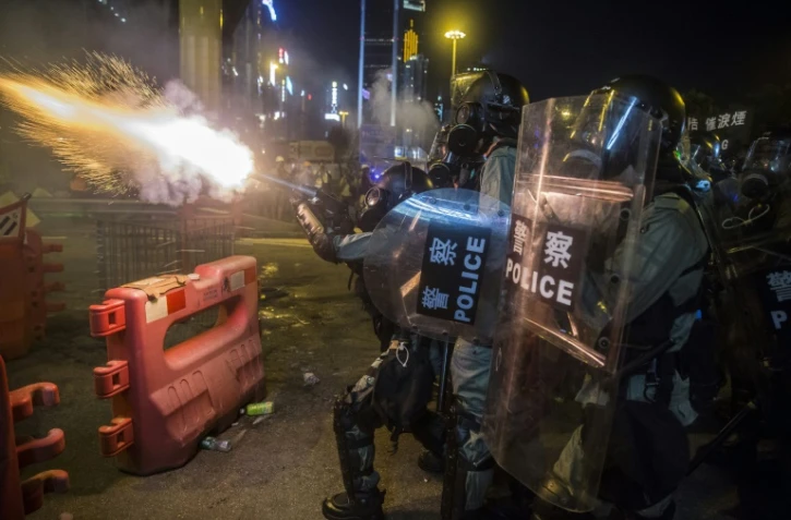 Des policiers tirent des canettes de gaz lacrymogène lors d'une manifestation à Hong Kong, le 4 août 2019