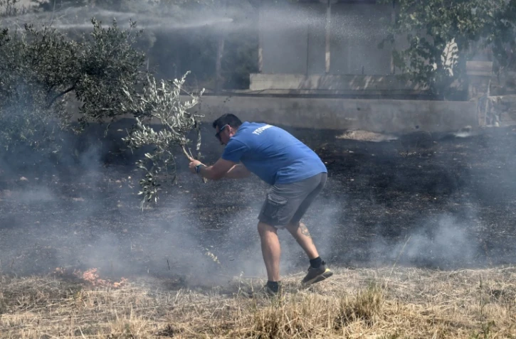Un habitant combat les flammes qui s'approchent des maisons à Dikella près d'Alexandroupoli en Grèce le 23 août 2023