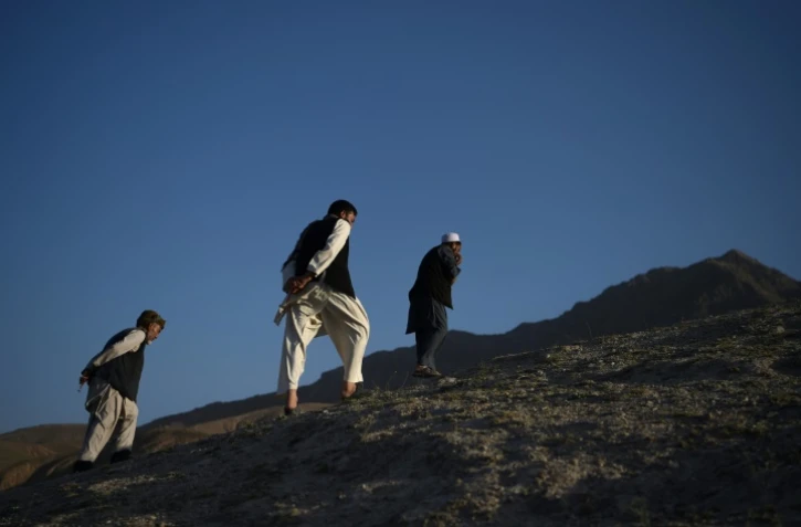 Des Afghans gravissent une colline, le 21 juillet 2017 à Kaboul