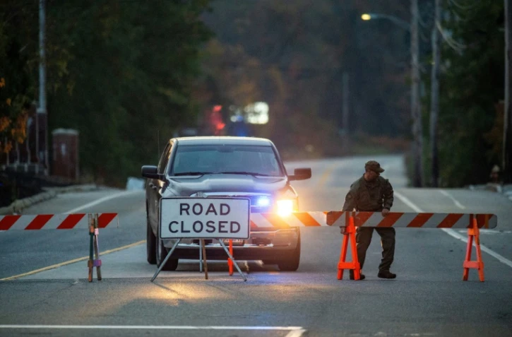 Barrage de police sur la route menant à un bar de Lewiston, lieu d'une tuerie la veille, le 26 octobre 2023 dans le Maine