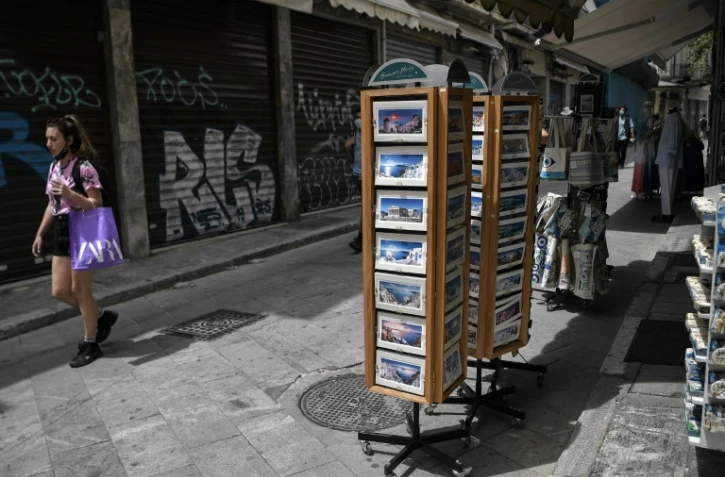 Une femme passe près d'une boutique de souvenirs dans le centre d'Athènes, le 12 mai 2021
