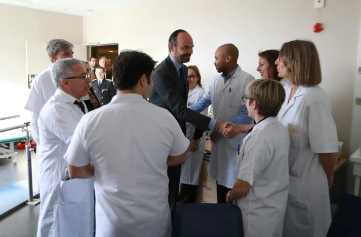 Edouard Philippe serre la main de membres du personnel médical lors d'une visite du centre hospitalier Simone Veil, à Eaubonne, dans le Val d'Oise, le 13 février 2018
