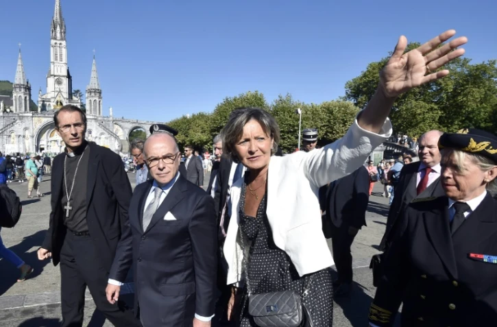 Le ministre de l'Intérieur Bernard Cazeneuve (c) entouré de l'évêque de Tarbes et de Lourdes Nicolas Brouwet (g), et de la maire de Lourdes Josette Bourdou (d), lors de sa visite à Lourdes, le 13 août 2016