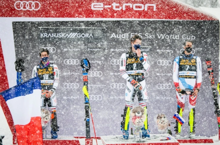 Le Français Clément Noël, vainqueur du slalom de Coupe du monde, entouré de son compatriote Victor Muffat-Jeandet (g, 2e) et du Suisse Ramon Zenhaeusern, le 14 mars 2021 à Kranjska Gora (Slovénie