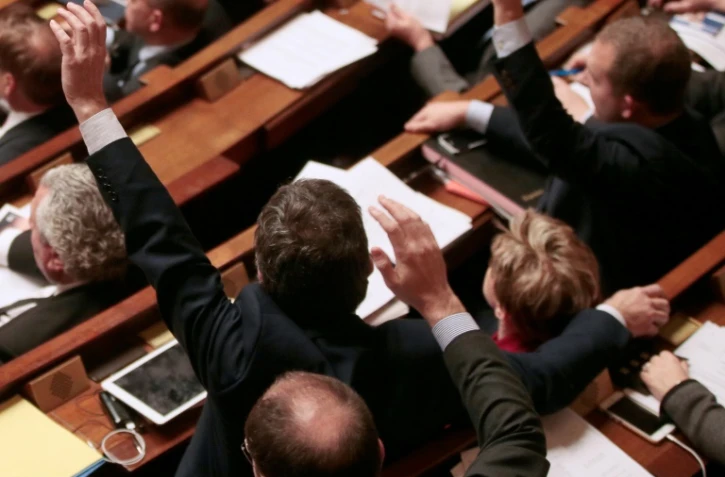 Des députés français votent à main levée des amendements à la constitution à l'Assemblée nationale française à Paris, le 9 février 2016