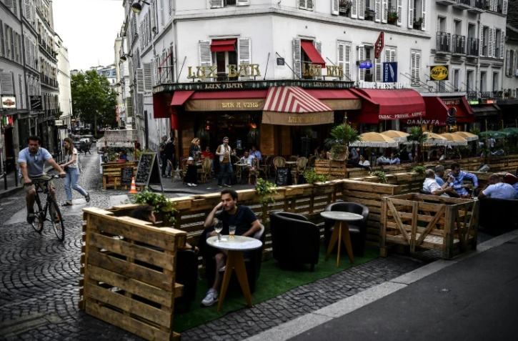 Des personnes prennent un verre à la terrasse élargie d'un bar à Paris, le 23 juillet 2020