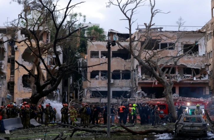 Les secours travaillent autour d'immeubles partiellement détruits par un missile iranien à tel-Aviv, le 16 juin 2025
