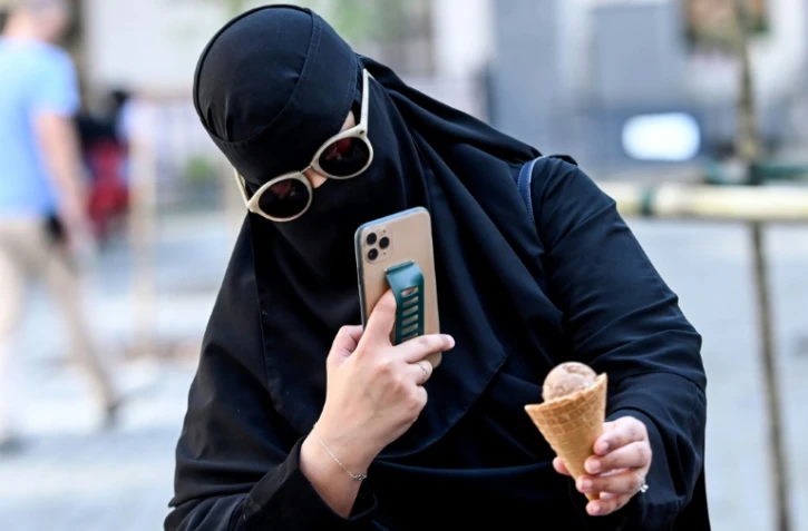 Une touriste saoudienne prend une photo de son cornet de glace, le 13 août 2021 à Lviv, en Ukraine