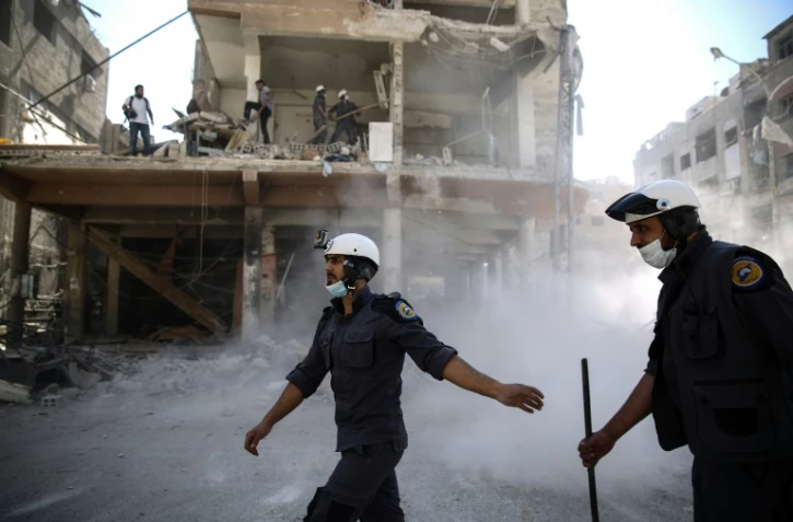 Les secours au milieu des décombres le 5 octobre 2016 dans un quartier détruit par les bombardements à Alep