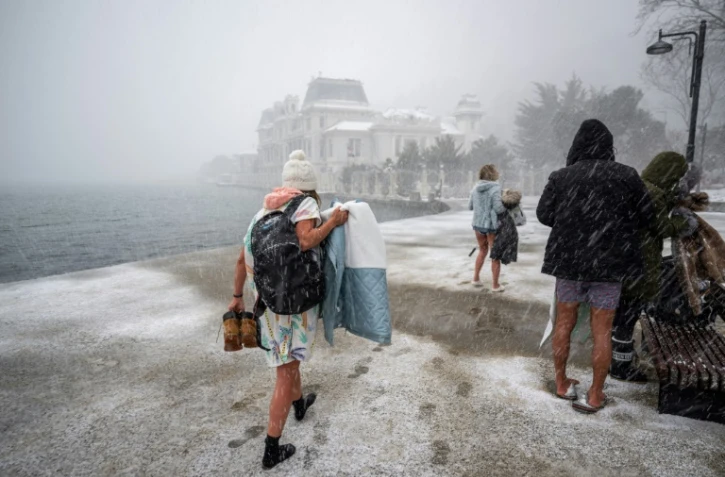 Des nageurs arrivent pour un bain dans les eaux du détroit du Bosphore, dans le quartier de Bebek, à Istanbul, le 22 février 2025
