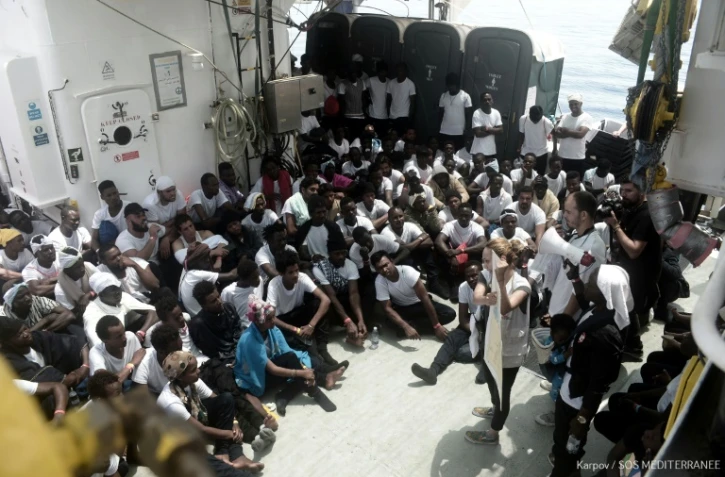 Des membres de l'ONG SOS Méditerranée s'adressent aux migrants à bord du navire Aquarius, le 11 juin 2018