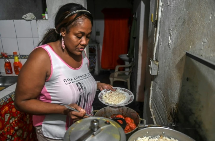 La Colombienne Elizabeth Mosquera, qui a perdu son emploi, prépar le dîner dans sa cuisine, le 7 décembre 2020 à Medellin, en Colombie