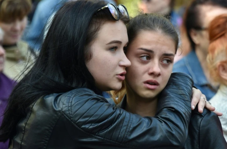 Deux jeunes femmes participent à une messe en hommage aux victimes de la tuerie de Kertch,  le 18 octobre 2018