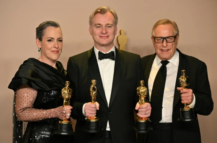 La productrice britannique Emma Thomas, le producteur Charles Roven, et le réalisateur britannique Christopher Nolan (au centre) à Hollywood, le 10 mars 2024