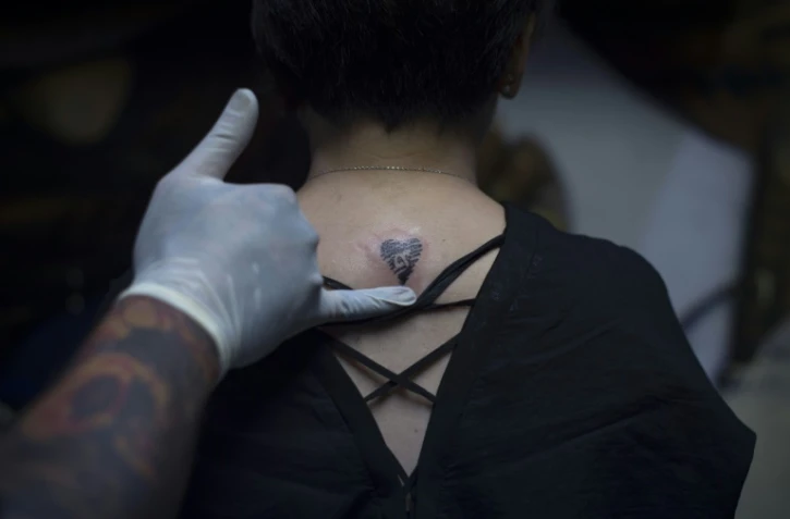 Un tatouage en forme de coeur orné du chiffre "9", en référence au nom officiel du défunt roi de Thaïlande, Rama IX 