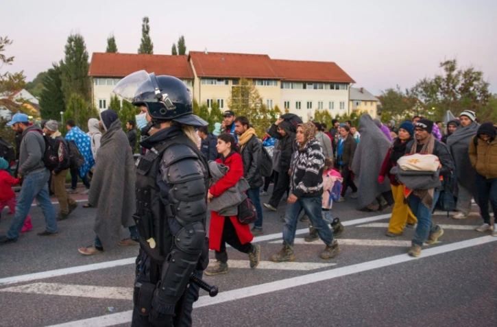 Des migrants et réfugiés traversent la frontière entre la Slovénie et l'Autriche, le 21 octobre 2015 à Sentilj, en Slovénie