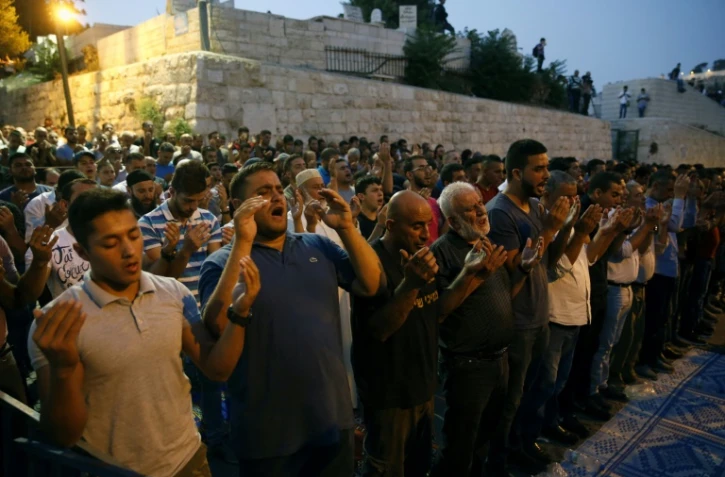 Des palestiniens musulmans prient devant la porte des Lions, à Jérusalem, le 27 juillet 2017