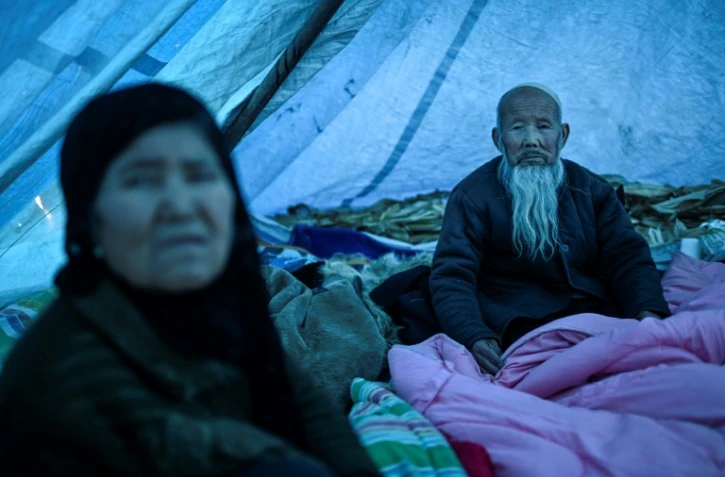 Des survivants du séisme de la province de Gansu, en Chine, se protègent du froid dans des abris de fortunen, le 20 décembre 2023 à Jishishan