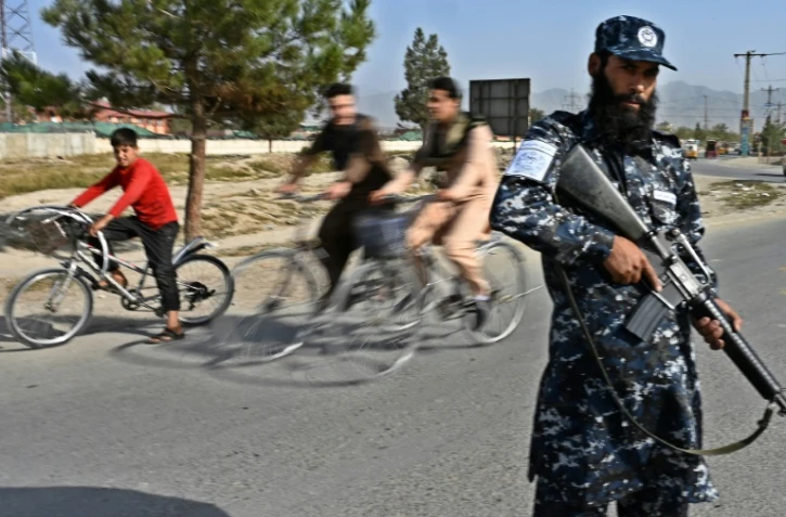 Un combattant taliban travaillant comme policier monte la garde à un poste de contrôle à Kaboul le 3 octobre 2021 