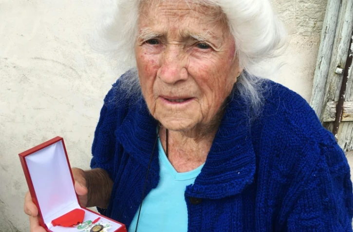 Geneviève Callerot, 102 ans, pose le 25 août 2018 à Saint-Aulaye (Dordogne), avec sa Légion d'honneur dont elle a été décorée pour avoir fait passer en zone libre réfugiés et juifs durand la 2nde Guerre mondiale  