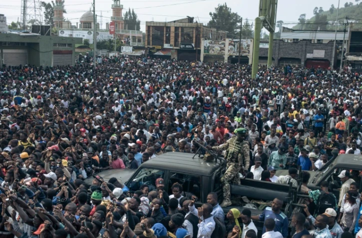 Un combattant du M23 sur une camionnette au milieu d'une foule rassemblée aux portes du Stade de l'Unité à Goma, le 6 février 2025 en RDC