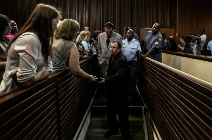 Willem Oosthuizen (C/G) et Theo Jackson (C/D), deux fermiers condamnés pour avoir tenté d'enfermer un homme noir dans un cercueil et menacé de le brûler, au tribunal de Middelburg, en Afrique du Sud, le 27 octobre 2017