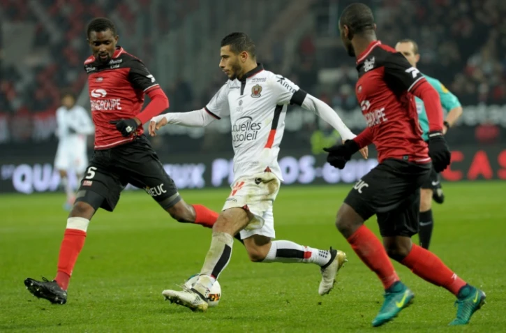Le mileu de Nice Younes Belhanda (c) à la lutte avec les joueurs de Guingamp Moustapha Diallo (g) et Jordan Ikoko au Roudourou, le 30 novembre 2016