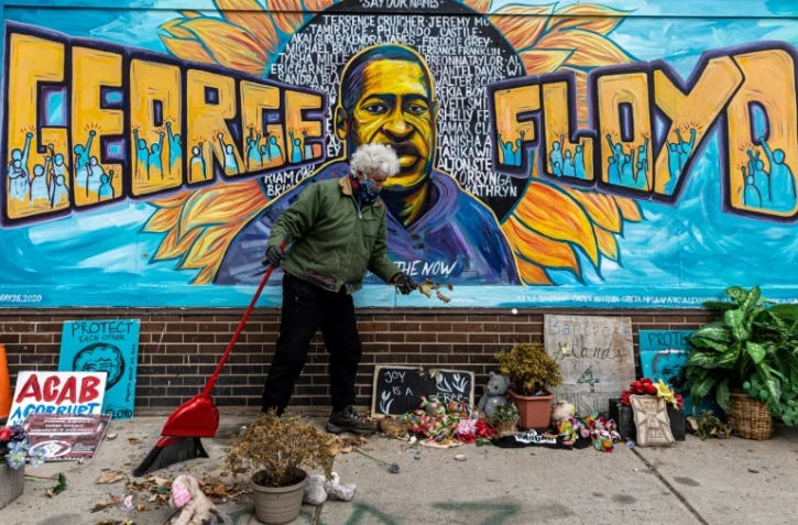 Minneapolis, le 28 mars 2021: un bénévole nettoie le mémorial érigé en l'honneur de George Floyd sur le site de sa mort