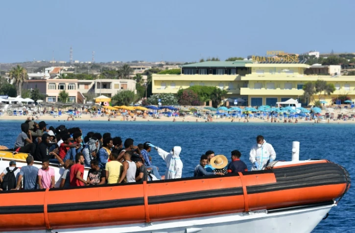 Des migrants en provenance de Tunisie et de Libye arrivent à Lampedusa à bord d'un bateau des gardes-côtes italiens, le 1er août 2020
