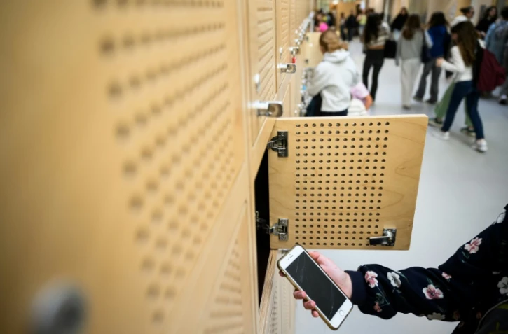 Une élève dépose son téléphone portable dans un casier après l'avoir éteint, au collège Auguste Brizeux à Lorient, le 5 septembre 2024 dans le Morbihan