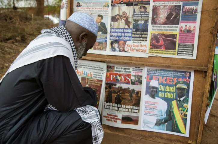 Un Malien regarde les Unes des journaux annonçant la réduction de la présence militaire française dans cette partie du Sahel, à Bamako le 11 juin 2021
