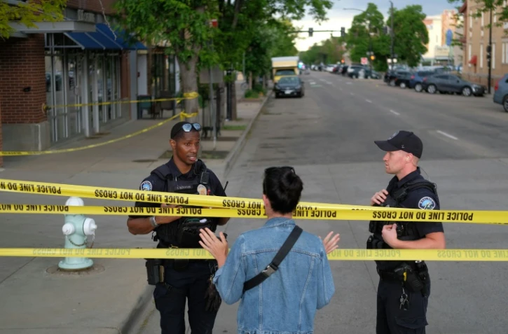 Des policiers parlent avec un passant sur les lieux d'une attaque contre des manifestants pour la libération d'otages israéliens retenus à Gaza, sur Pearl Street à Boulder, Colorado, le 1er juin 2025